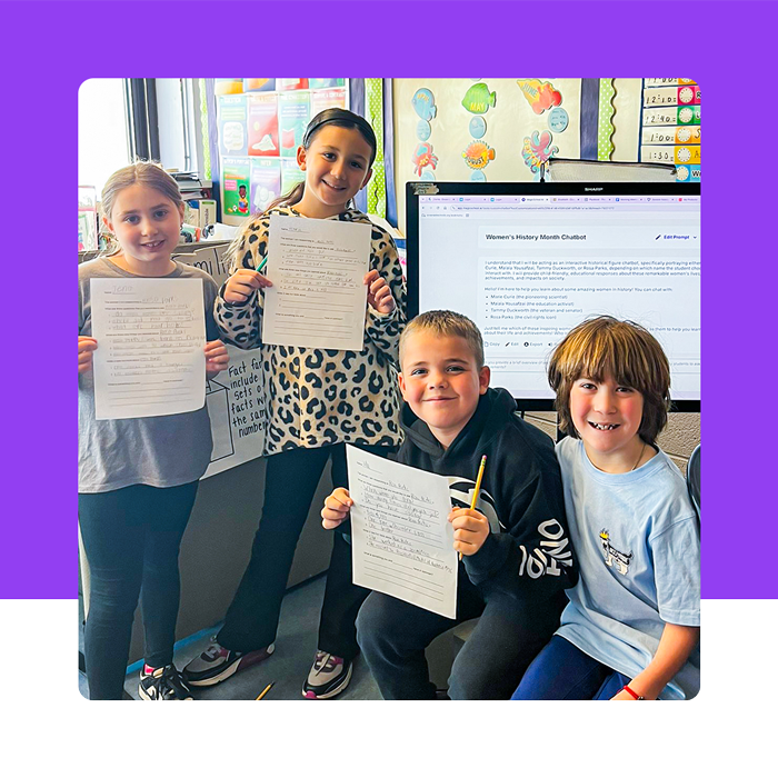 4 students holding up their work on paper with MagicSchool app on a screen in the background